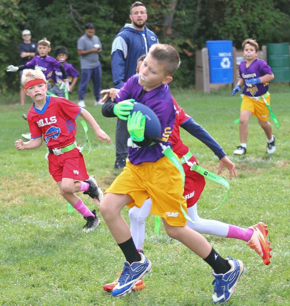A player sprints upfield with defenders in red chasing