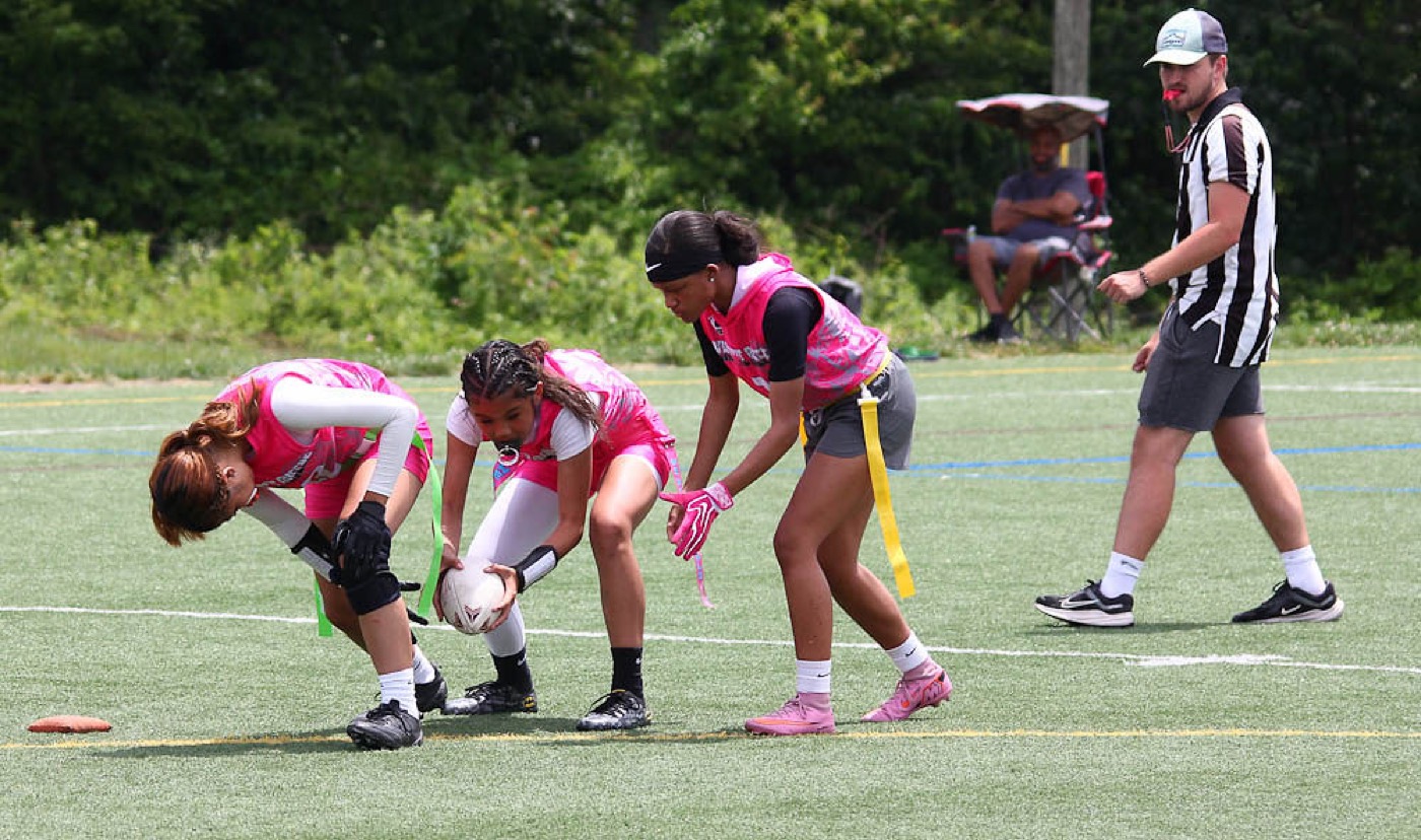 Girls line up at the line of scrimmage as the ball is snapped