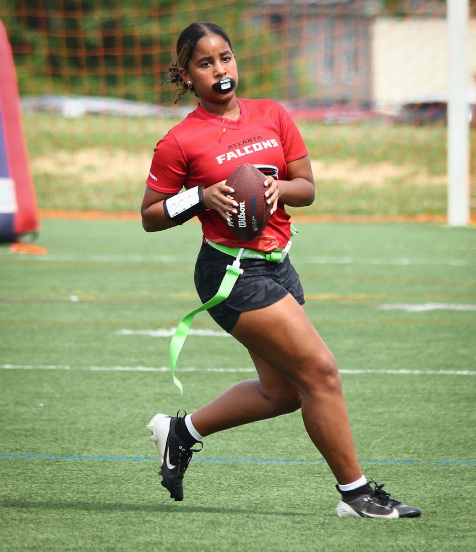 An All-Girls player in a Falcons jersey runs with the ball