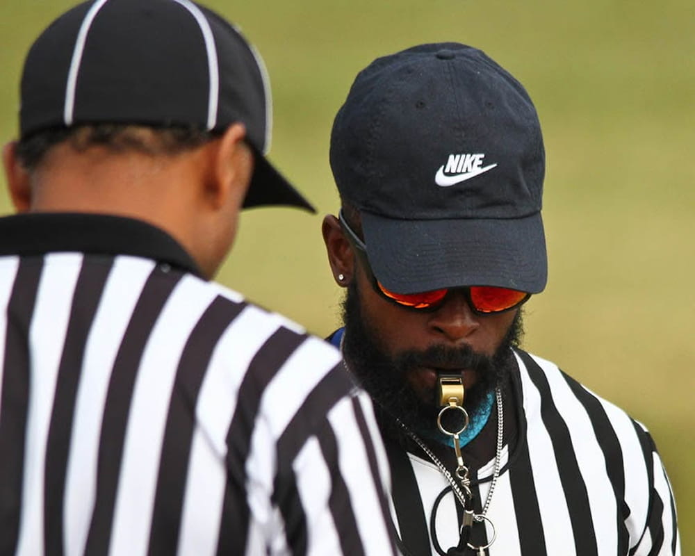 A referee blows the whistle during an Aim High flag game